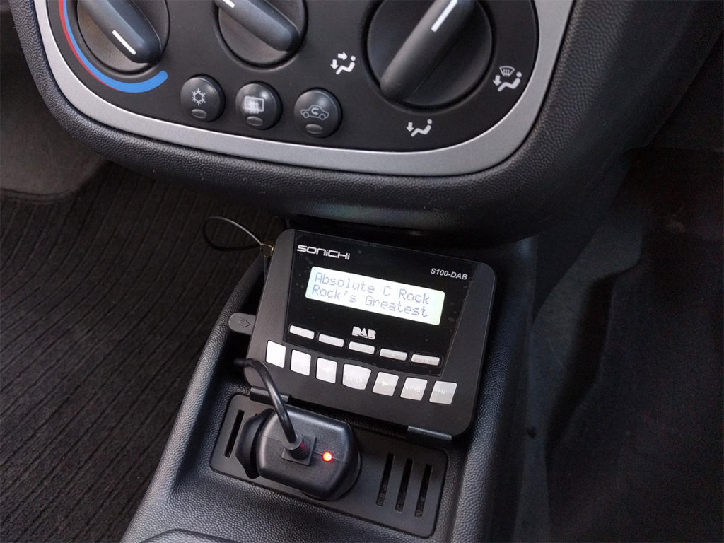 The Sonichi S100-DAB placed in the centre console with its 12V adapter